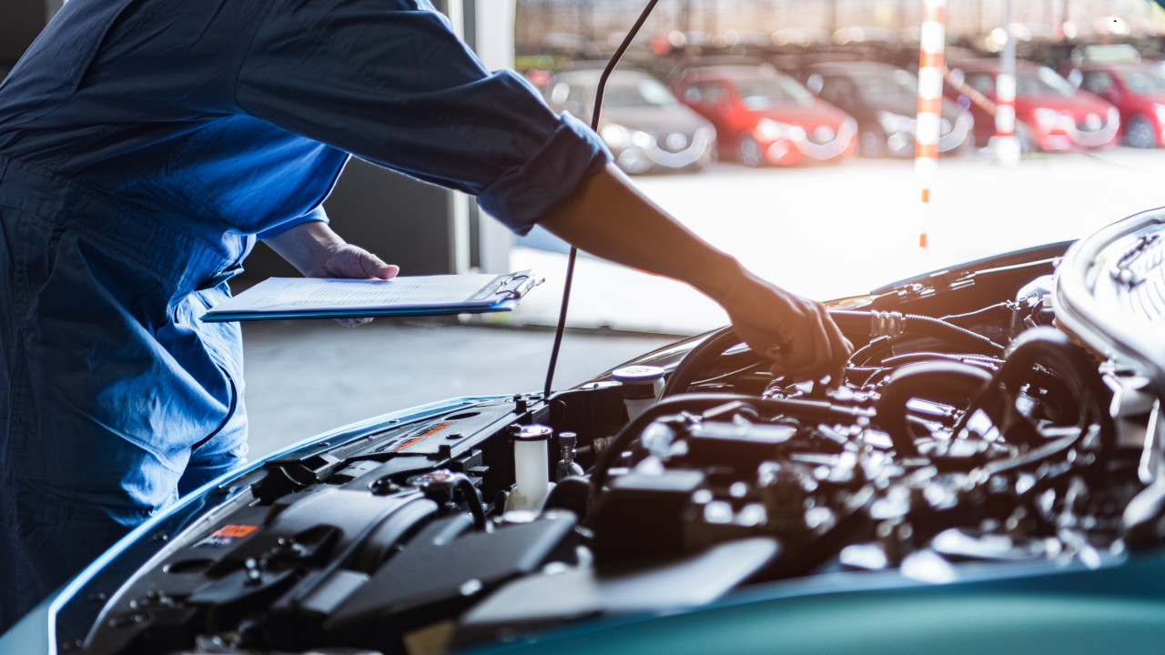 Technician inspecting car engine components, highlighting crankshaft role in vehicle performance.