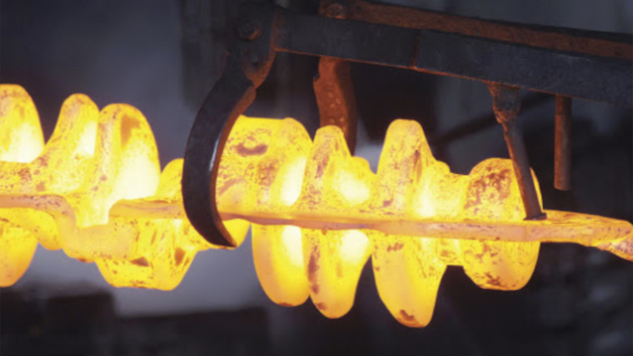 Glowing hot metal component undergoing forging or heat treatment, showcasing high-temperature crankshaft manufacturing.